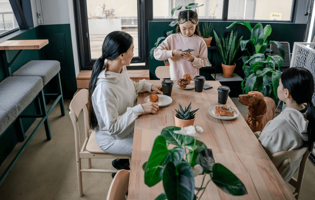 woman and her kids with dog at table