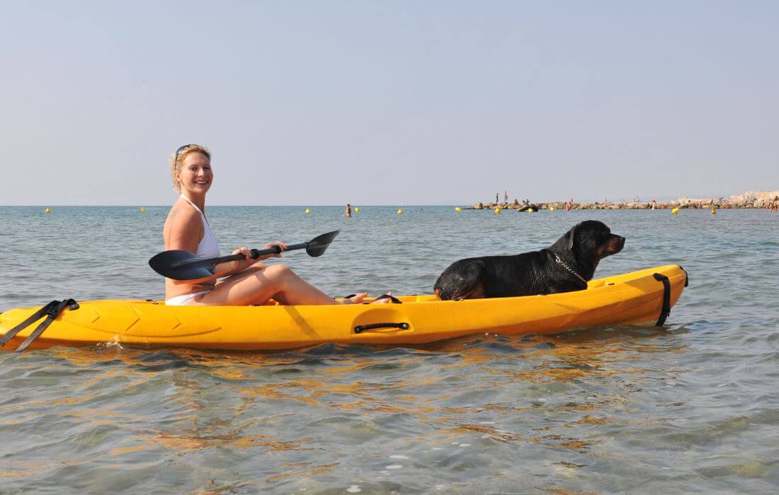 Woman Kayaking with Her Dog on Scenic Turquoise Lake