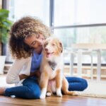 Young woman plays with new puppy at home